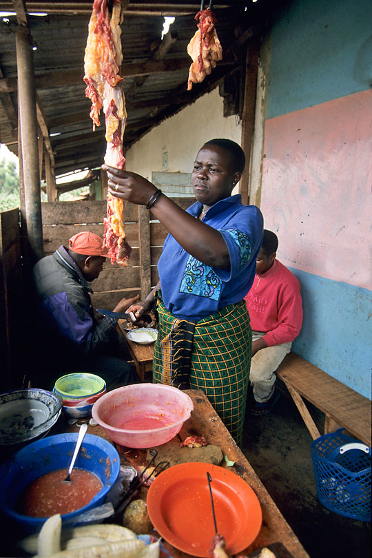 At a local Hoteli a woman cuts meat &lt;p&gt;to cook Nyama choma, grilled meat, often served &lt;p&gt;with cabbage, boiled rice and a spicy tomato sauce.