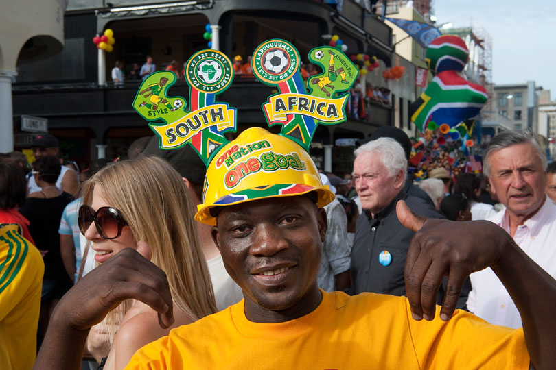 Fan celebrating the draw of the 2010 FIFA &lt;p&gt;World Cup  wearing a Mayoka soccer fan helmet
