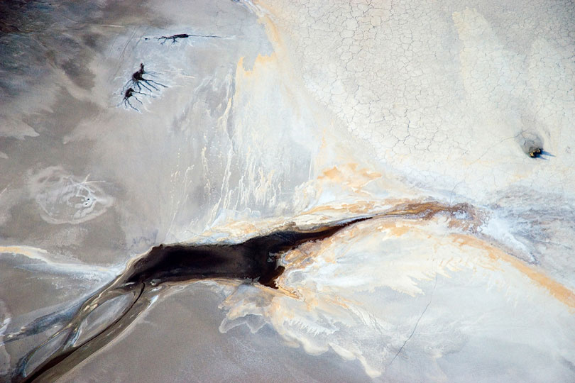 Springs form dark patches and abstract patterns on the shore&lt;p&gt; of Lake Natron, Tanzania