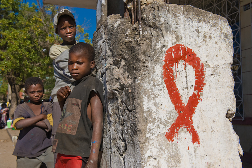 Street children standing at a pillar with a &lt;p&gt;painted HIV/AIDS ribbon, Quelimane Mozambique