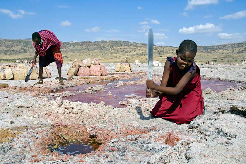 Soda mining, a young Massai girl cuts salt slabs &lt;p&gt;with a machete, Lake Natron, Tanzania,