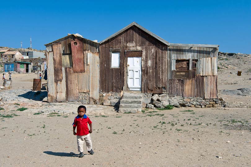 	Boy and an old house on the outskirts of Luederitz, Namibia