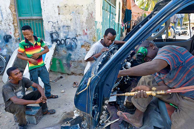 Welder repairing a crashed minibus in Stone Town, Zanzibar, Tanzania